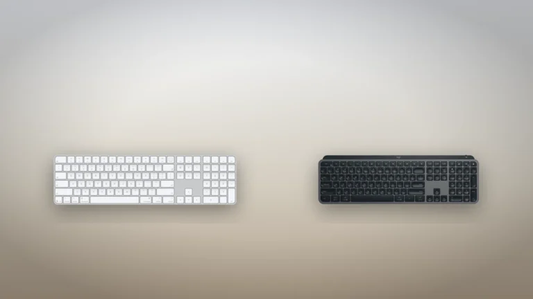 White Apple Magic Keyboard with Touch ID and Numeric Keypad beside a graphite Logitech MX Keys S, both seen from above