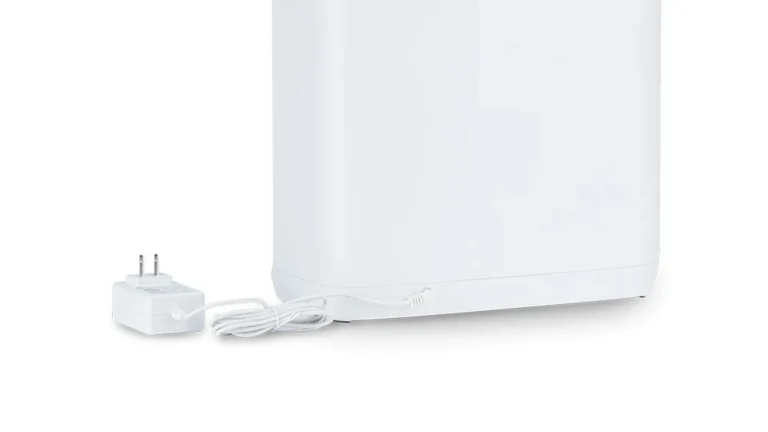 Lower rear of the white Levoit Vital 100S-P with its white external power adapter and coiled cable plugged into the base