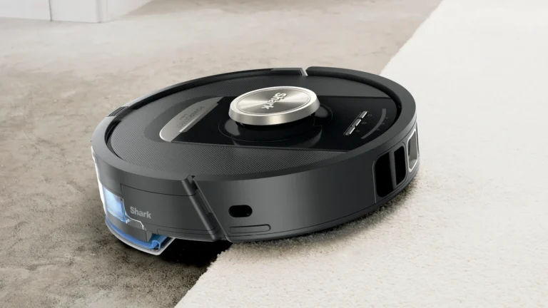Black Shark PowerDetect NeverTouch Pro robot driving from a hard floor onto a cream carpet, with its mop pad raised at the rear